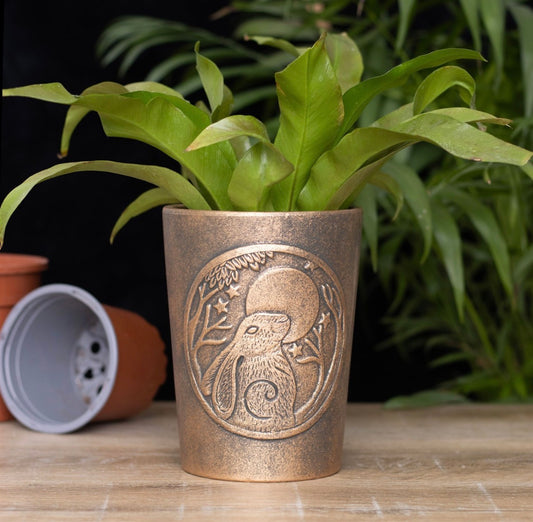Maceta de terracota color bronce con liebre mirando a la luna, diseñada por Lisa Parker.